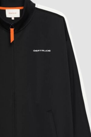 Détail logo et bandes blanches veste Dams Black Gertrude