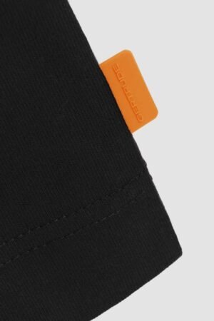 Détail étiquette orange Gertrude du T-shirt Darrylcore Black